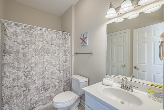 bathroom featuring toilet, a shower with shower curtain, and vanity