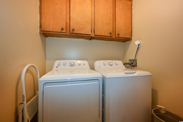 clothes washing area with cabinet space and washer and dryer