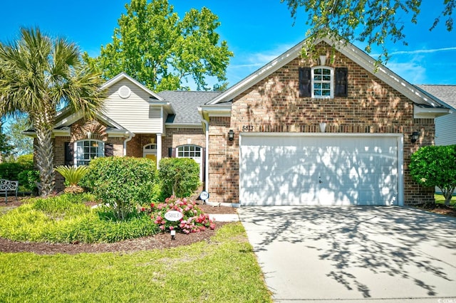 traditional-style house with concrete driveway, brick siding, and an attached garage