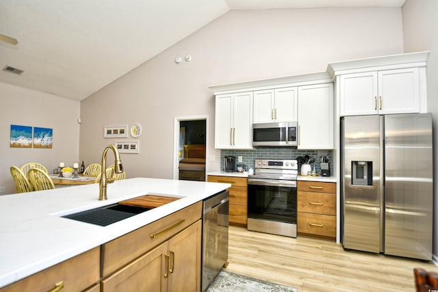 kitchen featuring visible vents, light countertops, tasteful backsplash, a sink, and appliances with stainless steel finishes