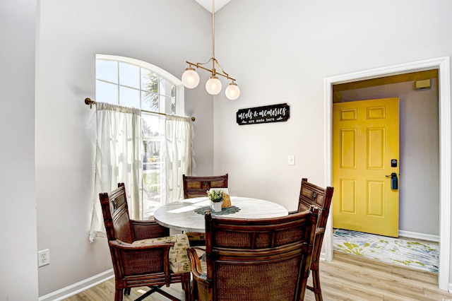 dining space with baseboards and light wood-style floors
