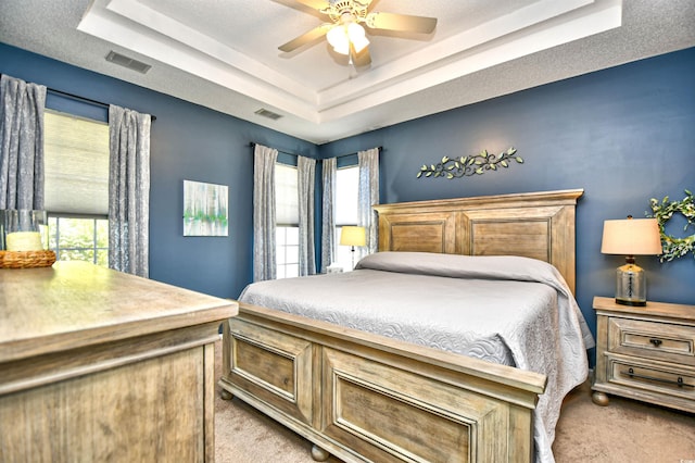 bedroom featuring visible vents, carpet flooring, a raised ceiling, and ceiling fan