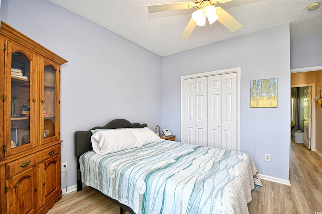 bedroom featuring light wood-style floors, a ceiling fan, baseboards, and a closet