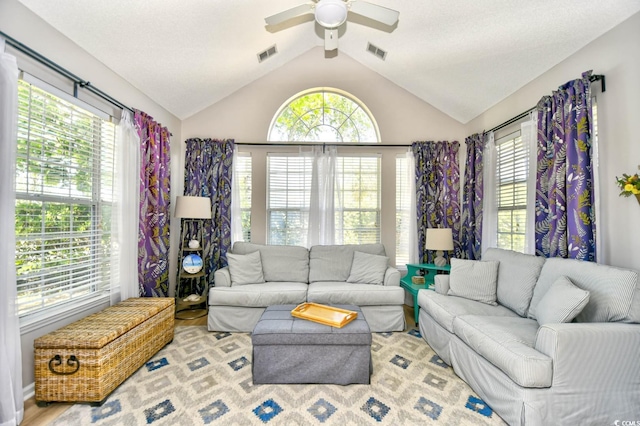 living room featuring a wealth of natural light, ceiling fan, and visible vents