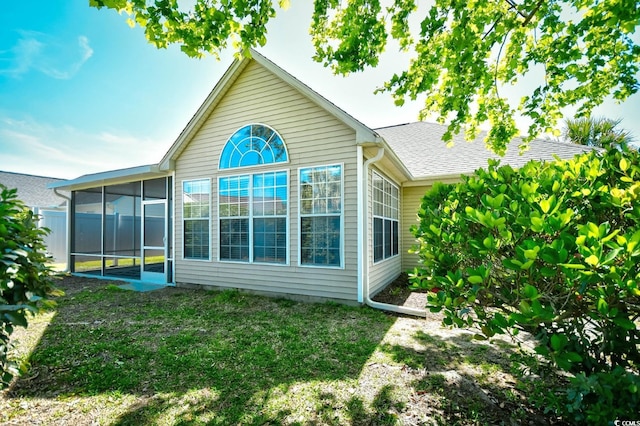 back of house with a yard and a sunroom