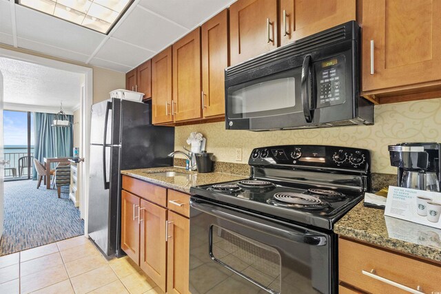 1105 S Ocean Blvd Unit 1024, Myrtle Beach, SC 29572 - kitchen featuring a sink, brown cabinetry, black appliances, and dark stone countertops