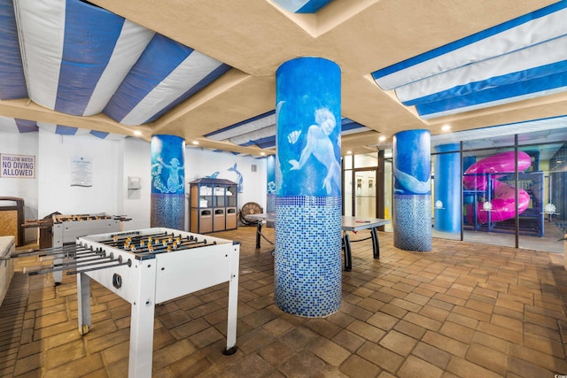 recreation room with brick floor