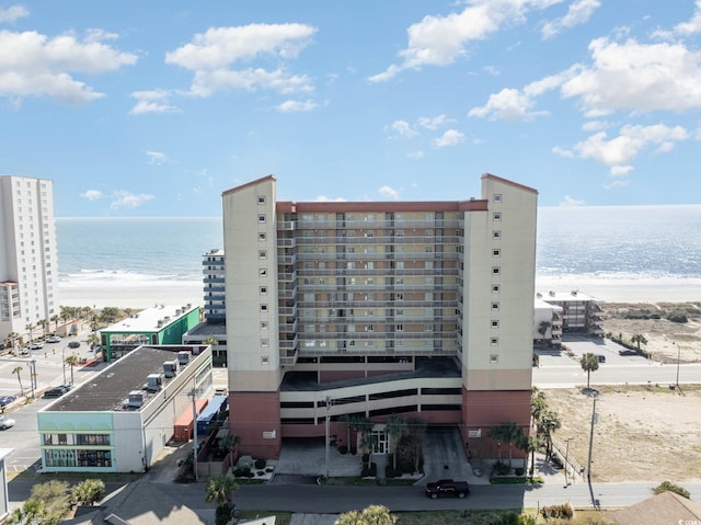 view of building exterior with a water view and a view of the beach