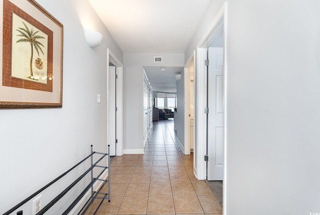 hallway with visible vents and light tile patterned floors
