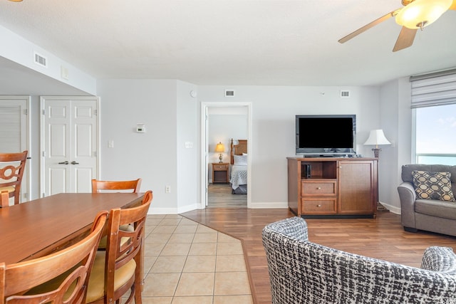 living room featuring visible vents, a ceiling fan, and light wood-style flooring