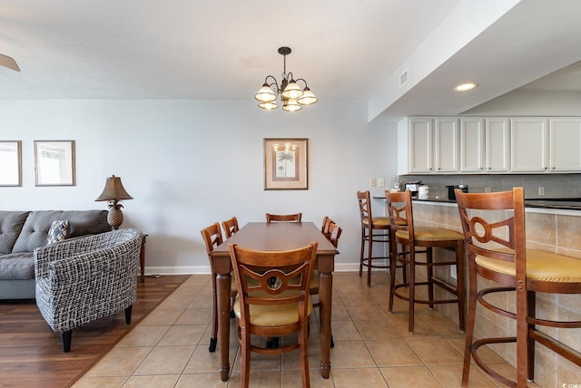 dining space featuring an inviting chandelier, baseboards, light tile patterned floors, and visible vents
