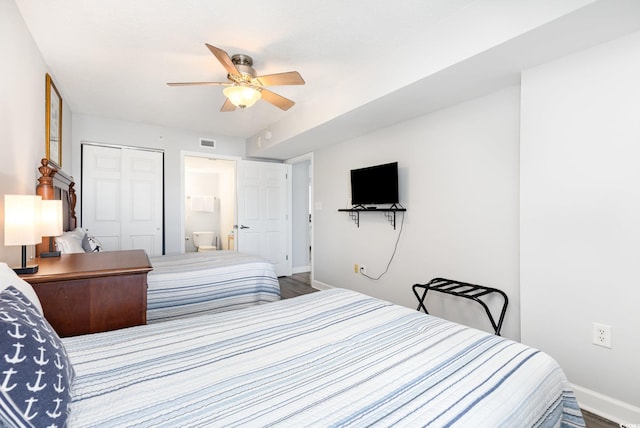 bedroom with visible vents, a closet, baseboards, ceiling fan, and ensuite bath