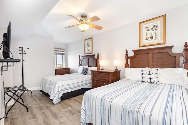 bedroom with baseboards, a ceiling fan, and light wood-type flooring