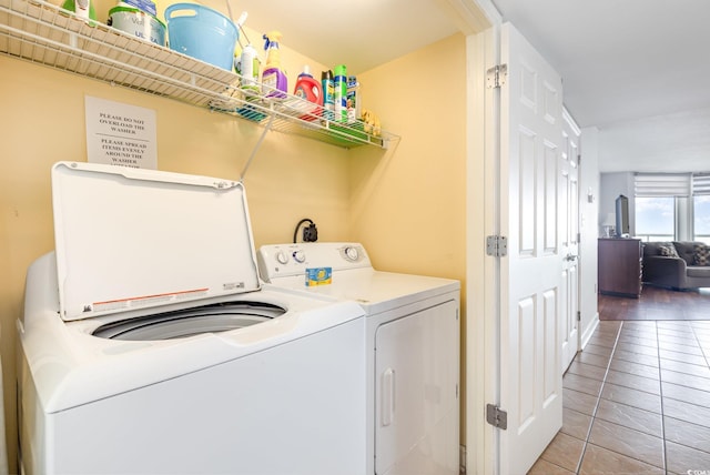 washroom with light tile patterned floors, laundry area, and washer and clothes dryer
