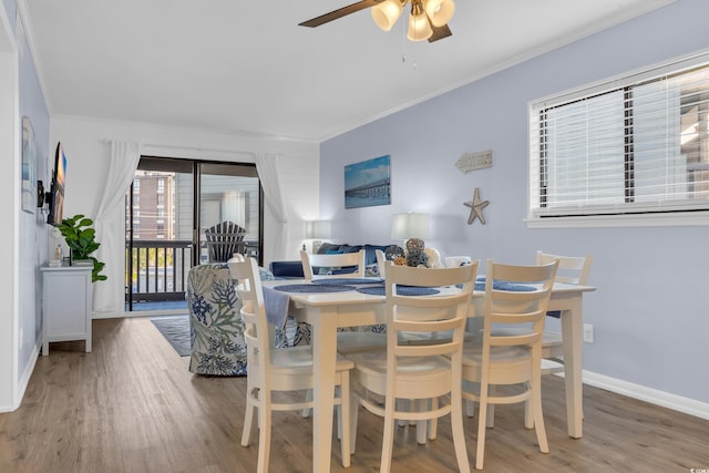 dining space with crown molding, a ceiling fan, baseboards, and wood finished floors
