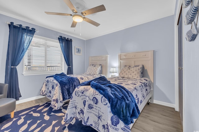 bedroom featuring ceiling fan, baseboards, ornamental molding, and wood finished floors