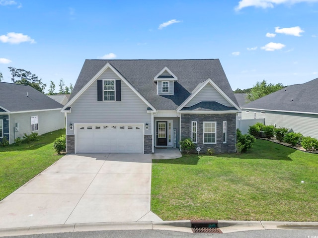 traditional home featuring an attached garage, a front yard, driveway, and stone siding