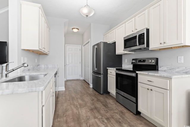 kitchen featuring a sink, white cabinetry, wood finished floors, and stainless steel appliances