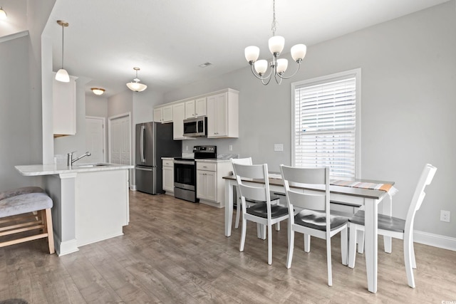 dining room featuring baseboards, a chandelier, and light wood-type flooring