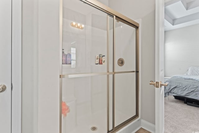 ensuite bathroom featuring baseboards, ensuite bathroom, and a stall shower