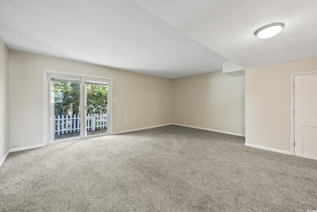 carpeted empty room featuring baseboards