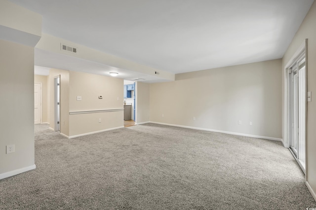 carpeted spare room featuring baseboards and visible vents