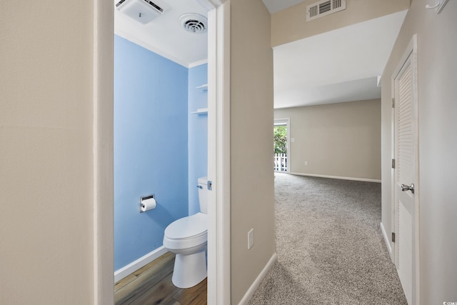 bathroom with baseboards, toilet, and visible vents