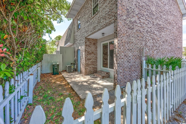 2701 Hillside Dr S Unit 1, North Myrtle Beach, SC 29582 - view of side of home featuring brick siding, central AC, a fenced backyard, and a patio area