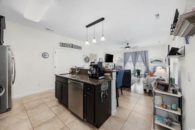 903 Ocean Pines Ct, North Myrtle Beach, SC 29582 - kitchen with stainless steel appliances, a sink, ceiling fan, light tile patterned flooring, and dark stone counters