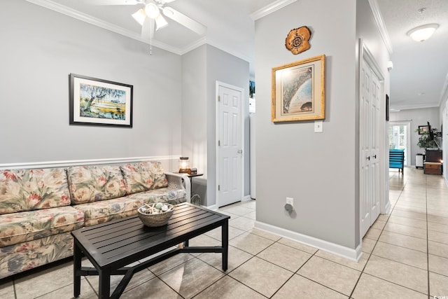 living area featuring baseboards, ornamental molding, ceiling fan, and light tile patterned floors