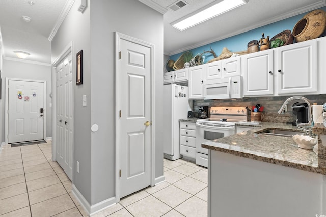 kitchen with a sink, white appliances, light tile patterned floors, visible vents, and ornamental molding