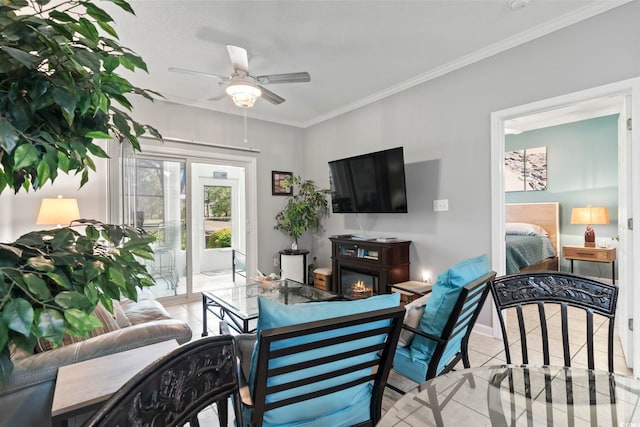 living area with crown molding, tile patterned floors, baseboards, and a ceiling fan