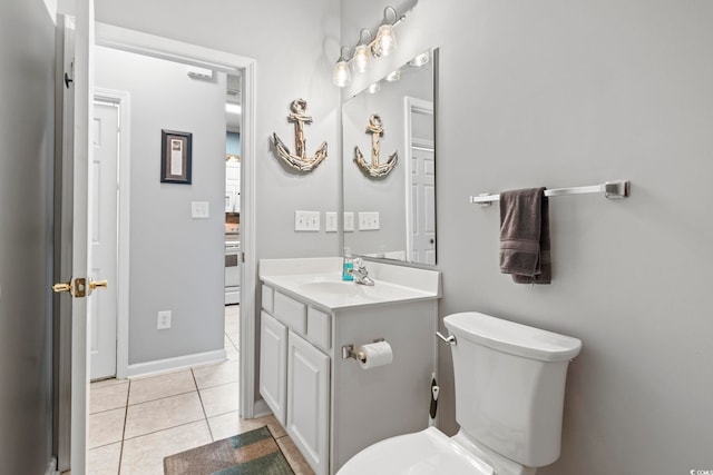 bathroom featuring vanity, tile patterned floors, baseboards, and toilet
