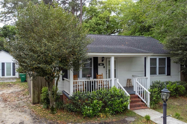 bungalow-style home featuring a shingled roof and covered porch