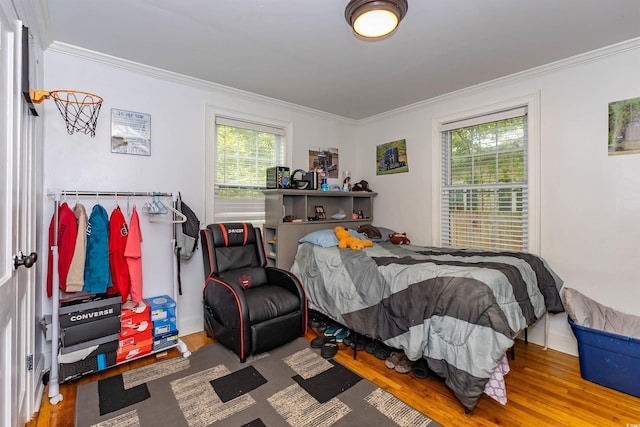 bedroom featuring crown molding, multiple windows, and wood finished floors
