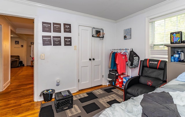 sitting room with ornamental molding and wood finished floors