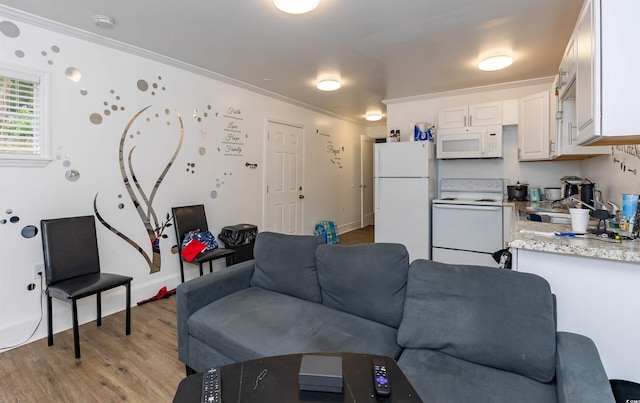 living area with light wood-style floors and ornamental molding