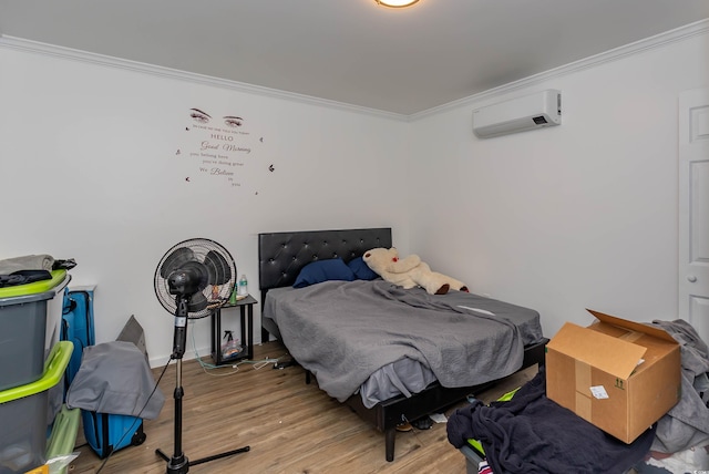 bedroom with crown molding, light wood-style flooring, and a wall unit AC