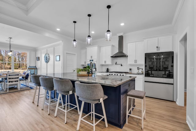 kitchen featuring backsplash, refrigerator with glass door, white cabinetry, dark stone counters, and wall chimney exhaust hood