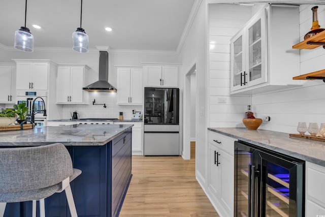 kitchen with wall chimney range hood, refrigerator with glass door, beverage cooler, and crown molding