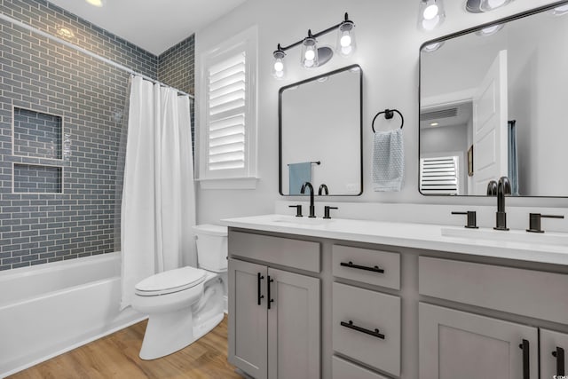 full bath featuring visible vents, a sink, wood finished floors, and toilet