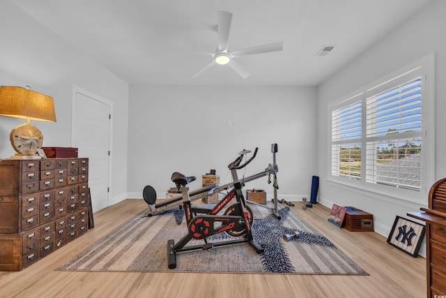 workout room featuring baseboards, ceiling fan, wood finished floors, and visible vents