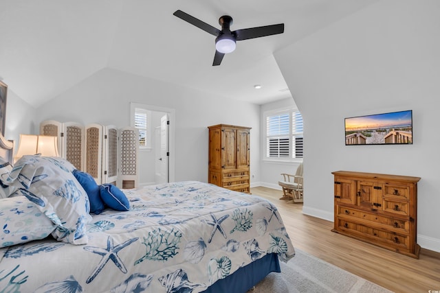 bedroom featuring baseboards, multiple windows, and light wood finished floors