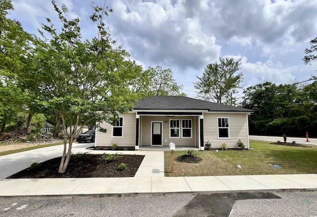 bungalow featuring covered porch and a front lawn