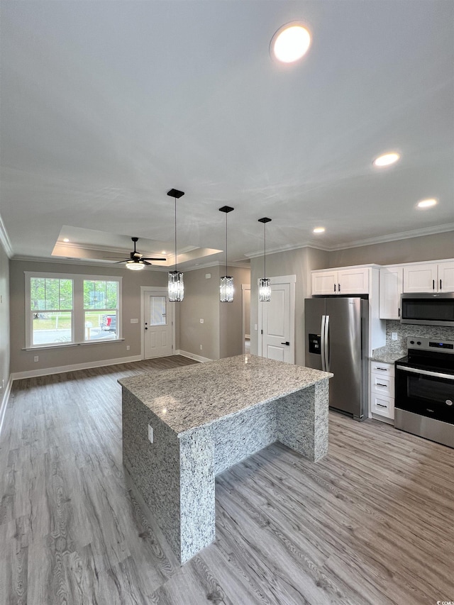 kitchen featuring crown molding, light wood-style floors, stainless steel appliances, and white cabinetry
