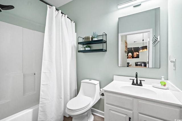 bathroom featuring toilet, shower / bath combo with shower curtain, and vanity