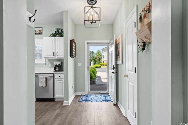 entryway with a healthy amount of sunlight, baseboards, wood finished floors, and a notable chandelier