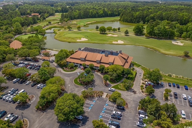aerial view with view of golf course, a water view, and a forest view