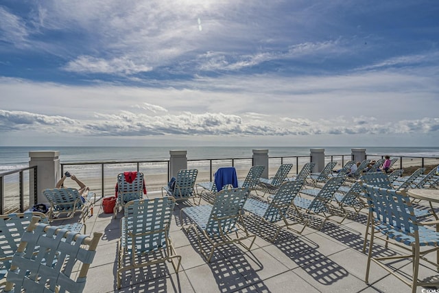 view of patio / terrace featuring a beach view and a water view