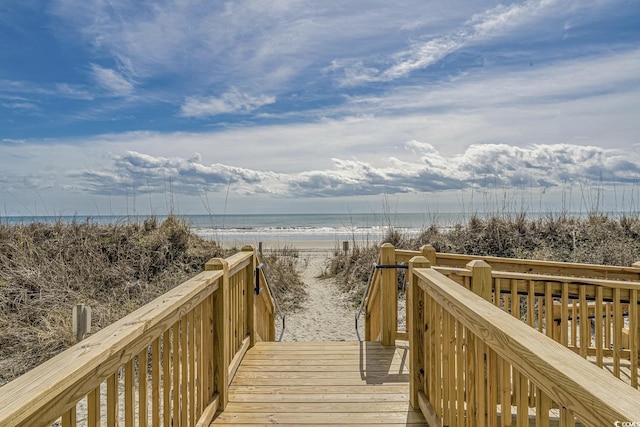 view of community featuring a beach view and a water view
